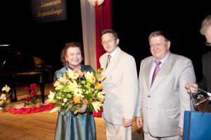 Elzbieta Dedek z kwiatami i burmistrzowie miasta